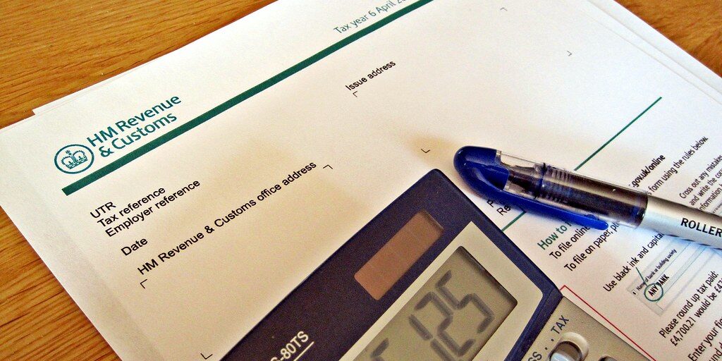 5856586617_16e98426e4_b hmrc tax return form with pen and calculator
