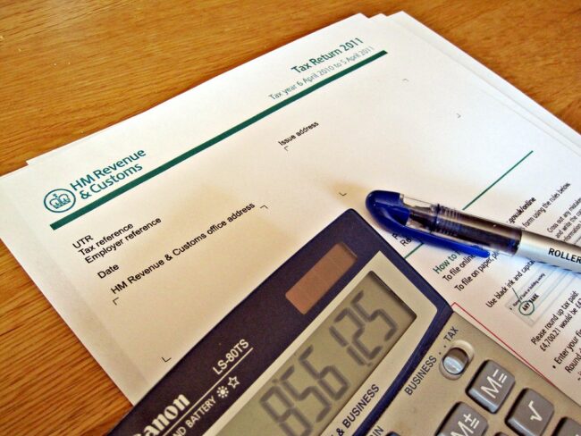 5856586617_16e98426e4_b hmrc tax return form with pen and calculator